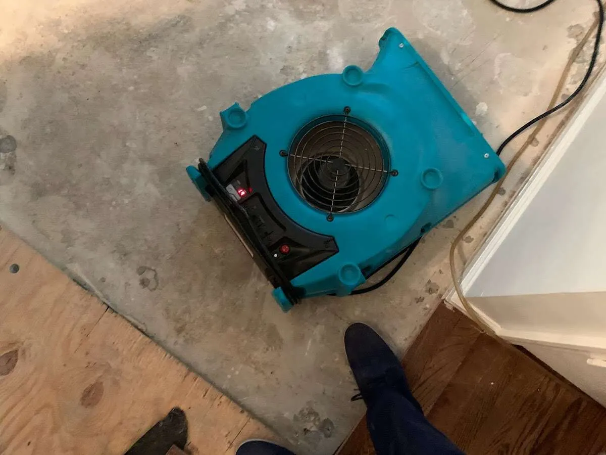 Air mover drying subfloor during Commercial Water Damage Restoration in North Kansas City